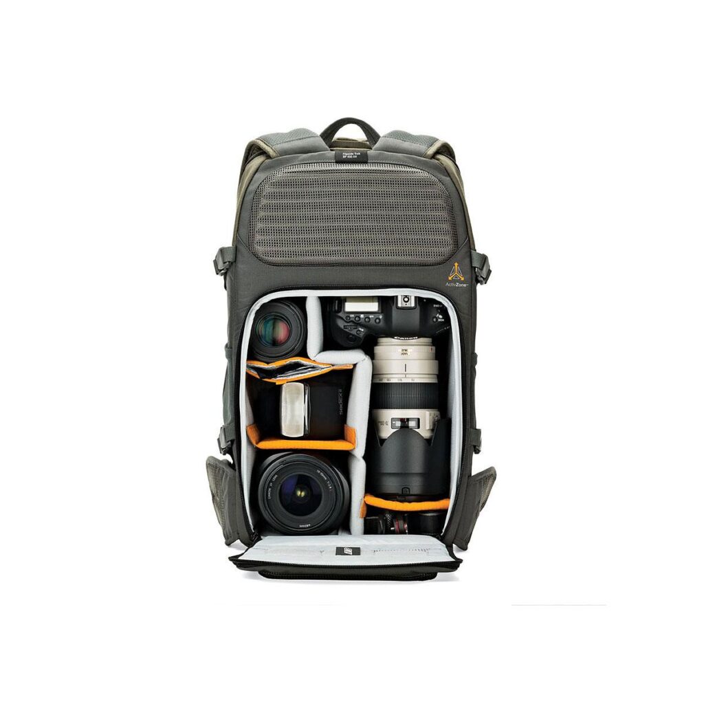Lowepro_Flipside_Trek_450_001 Lowepro Flipside Trek 450 -kamerareppu on auki ja vetoketju auki, ja siinä näkyvät siististi järjestetyt kamerarungot, objektiivit ja tarvikkeet pehmustetuissa lokeroissa. Harmaa reppu seisoo pystyasennossa tavallista valkoista taustaa vasten.