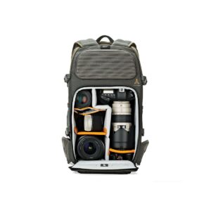 Lowepro_Flipside_Trek_450_001 Lowepro Flipside Trek 450 -kamerareppu on auki ja vetoketju auki, ja siinä näkyvät siististi järjestetyt kamerarungot, objektiivit ja tarvikkeet pehmustetuissa lokeroissa. Harmaa reppu seisoo pystyasennossa tavallista valkoista taustaa vasten.