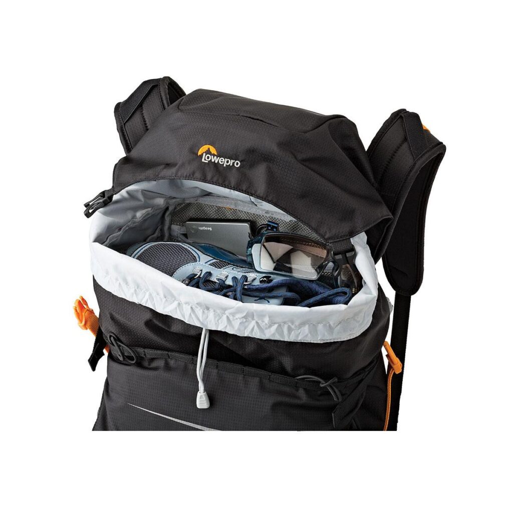 Lowepro_Photo_Sport_BP_300_AW_II_001 Lowepro Photo Sport BP 300 AW II MUSTA -reppu näytetään avattuna, ja sen sisältä paljastuvat lenkkarit, silmälasit ja kannettava tietokone tai tabletti. Siinä on pehmustetut olkahihnat ja oranssit korostukset.