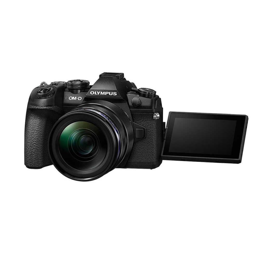 olympus_om-d_e-m1_mark_ii_12-40_pro_kit_0001 Olympus OM-D E-M1 Mark II, jossa on 12-40mm f/2.8 PRO -objektiivi, musta, jossa on oikealle ulosvedetty LCD-näyttö valkoista taustaa vasten.