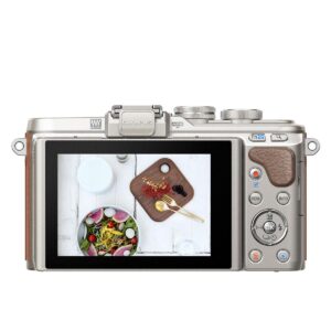 ID: 23326 Olympus Pen E-PL8 + 14-42mm EZ ruskea näkyy takaa, ja sen näytöllä näkyy salaatti ja ruokailuvälineet. Kamerassa on useita painikkeita, valintakiekkoja ja oikealla puolella nahkamainen kahva.