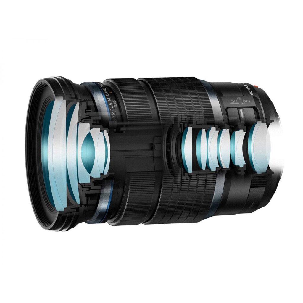 OM System M.Zuiko Digital ED 12-100mm f/4 IS PRO -objektiivin poikkileikkauskuva näyttää sen sisäiset sinisävyiset lasielementit ja optisen rakenteen mustan sylinterimäisen linssirungon sisällä.