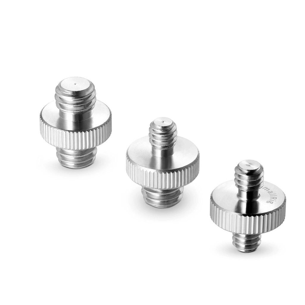 SmallRig_1262 Kolme SmallRig-kaksoiskärjistä muunnosruuvia (pakkaus 1262), joissa on hopeaa metallia, harjatut reunat ja uroskierteet molemmissa päissä, on sijoitettu valkoiselle taustalle.