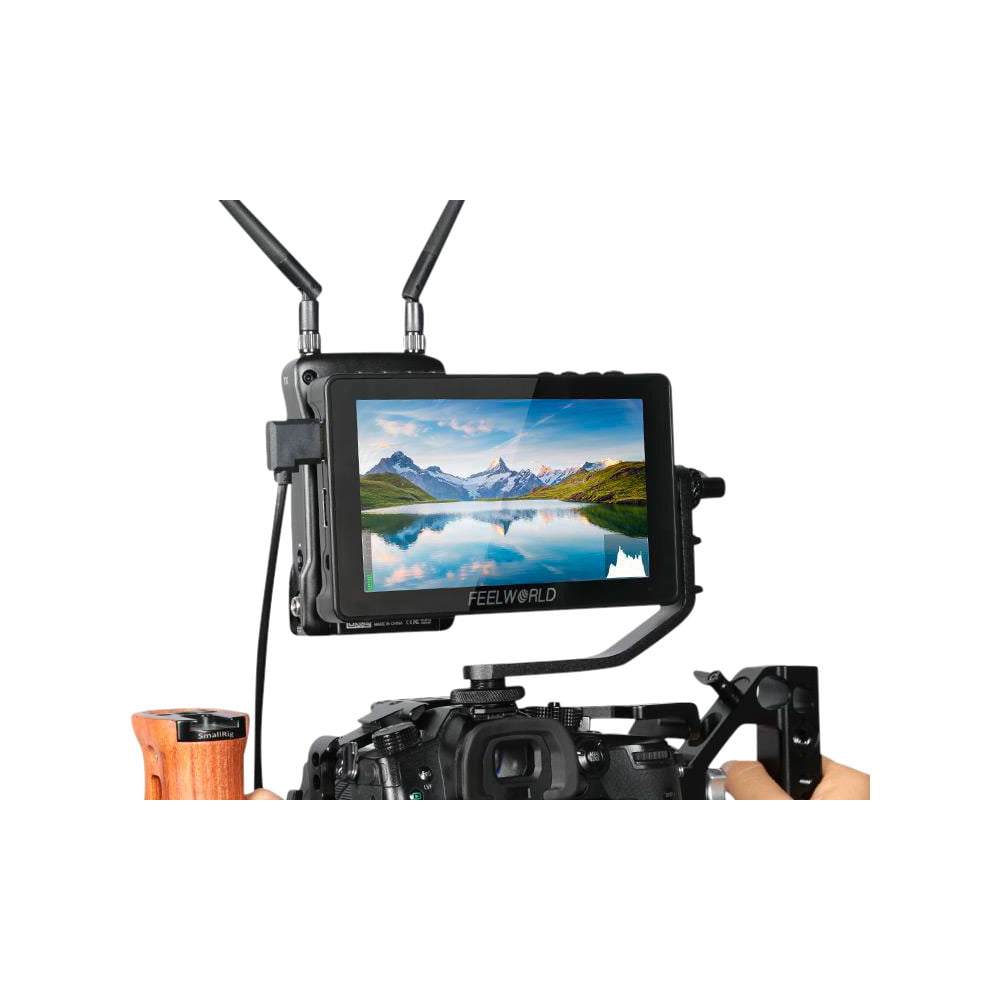 feelworld_f5_pro_v4_03 Feelworld F5 PRO V4 6" -monitori on asennettu kameralaitteeseen, ja se näyttää maiseman, jossa on vuoria, järvi ja sininen taivas; kaksi antennia on kiinnitetty monitoriin.