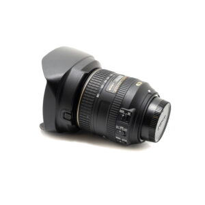 Käytetty Nikon Z6 II (Kunto K5, 22 kuukauden takuu, suljinlukema 1100) -kamera, jossa on musta objektiivi, vastavalosuoja ja suojus kiinnitettynä, näkyvät kytkimet ja kultaiset kirjaimet valkoisella pohjalla.