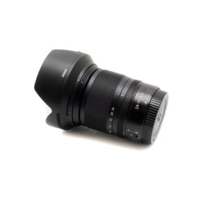 Nikon Z6 II -kamera (Kunto K5, 22kk takuu, suljinluku 1100) - Käytetty näkyy valkoisella taustalla ja siihen on kiinnitetty linssinsuojus, ja siinä näkyy zoomaus- ja tarkennusrenkaat, joissa on merkintä 24-70mm f/4 S.