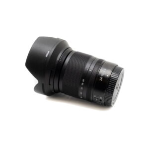 Nikon Z6 II -kamera (Kunto K5, 22kk takuu, suljinluku 1100) - Käytetty näkyy valkoisella taustalla ja siihen on kiinnitetty linssinsuojus, ja siinä näkyy zoomaus- ja tarkennusrenkaat, joissa on merkintä 24-70mm f/4 S.