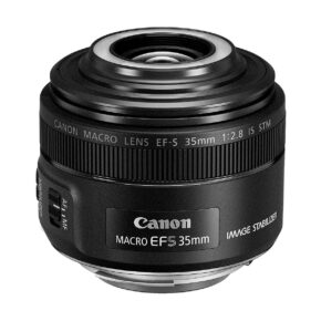 Canon_EF-S_35mm_f_2_8_Macro_IS_STM_001 Canon EF-S 35mm f/2.8 Macro IS STM -objektiivi näytetään kuvakulmasta, ja sen yksityiskohtainen tynnyri, tuotemerkki, tarkennuskytkin ja tekniset tiedot korostuvat.