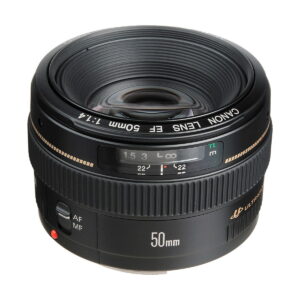 Canon_EF_50mm_f_1_4_USM_002 A Canon EF 50mm f/1.4 USM lens, with black body and distance scale window, is visible from an angle to highlight the glass and markings. The lens has automatic and manual focus switches.