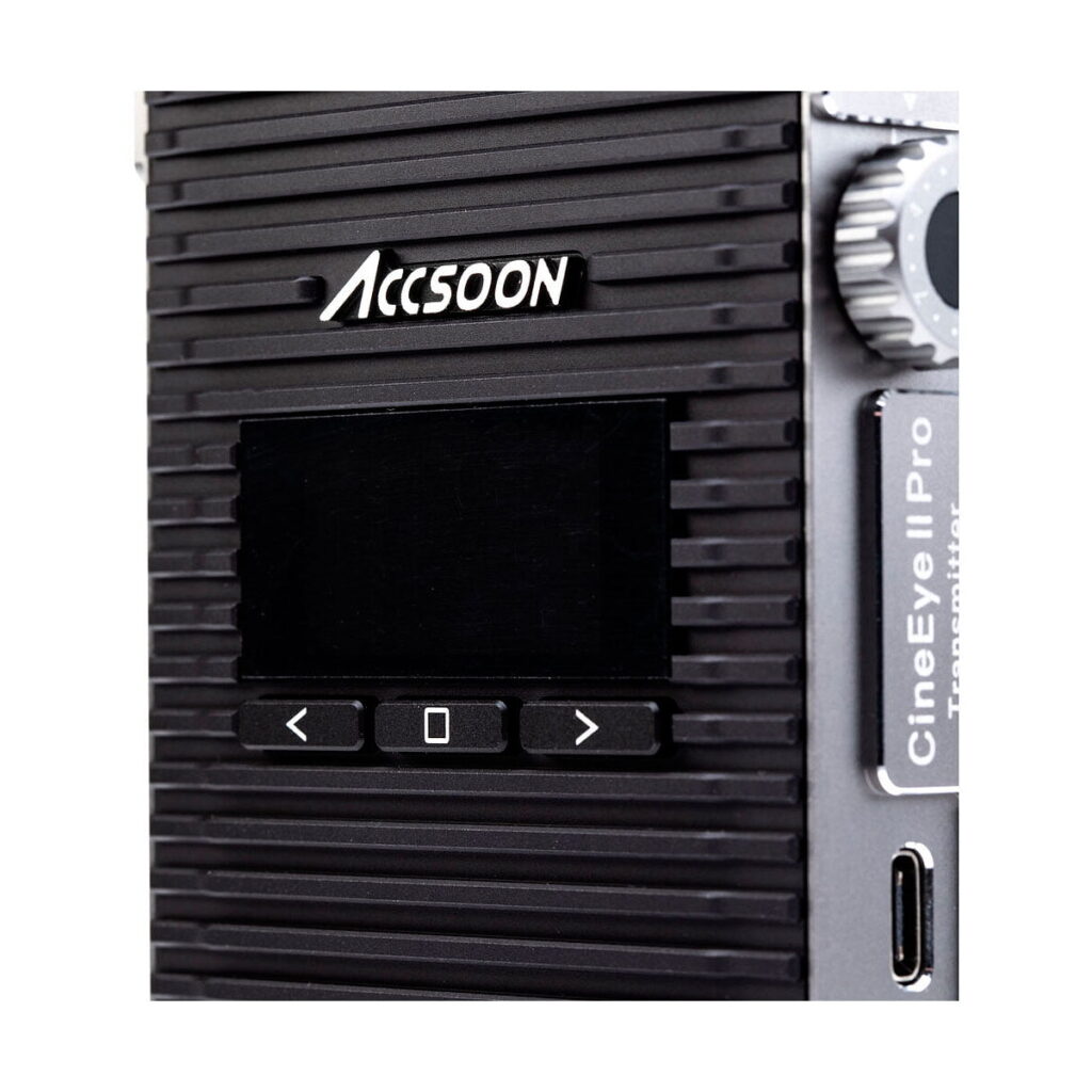 Accsoon_CineEye_2_Pro_003 Lähikuva Accsoon CineEye 2 PRO 2.4 & 5GHz WiFi Transmitter HDMI -lähettimestä, jossa on musta harjattu pinta, pieni näyttö, ohjauspainikkeet, hopeinen nuppi ja USB-C-portti oikealla puolella.