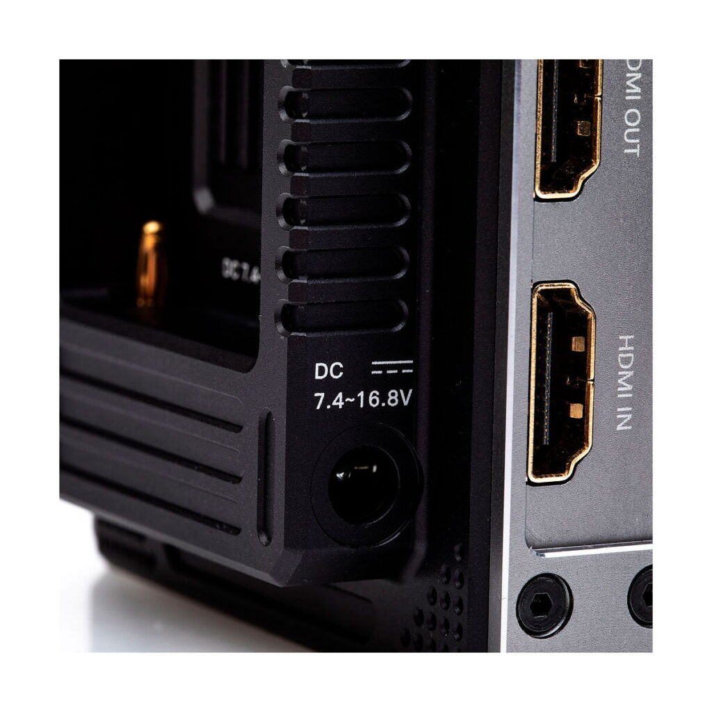 Accsoon_CineEye_2_Pro_011 Lähikuva Accsoon CineEye 2 PRO 2.4 & 5GHz WiFi Transmitter HDMI -lähettimestä, jossa näkyy DC-virtasyöttö, jossa on merkintä 7,4-16,8V, ja kaksi HDMI-porttia, joissa on merkinnät HDMI OUT ja HDMI IN sen metallisessa paneelissa.
