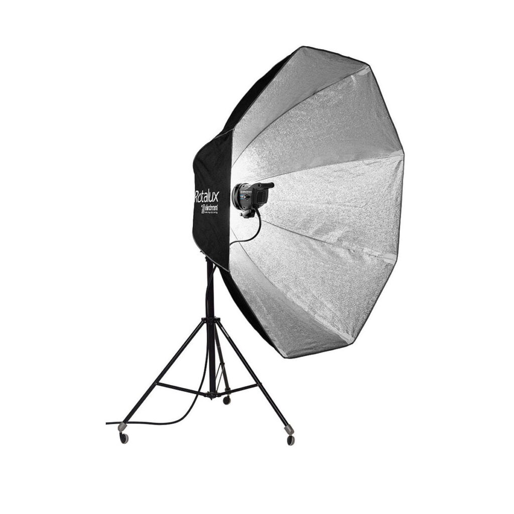 Elinchrom Rotalux 150cm Indirect Softbox on suuri musta ja hopeinen kahdeksankulmainen studiovalaistuksen softbox, joka on asennettu pyörillä varustettuun jalustaan.