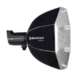 Elinchrom_Rotalux_Deep_Octabox_70cm_003 Studiostroboskooppivalaisin, johon on kiinnitetty suuri musta-hopea Elinchrom Rotalux Deep Octabox 70cm softbox, joka on suunniteltu ammattimaiseen valokuvaukseen.
