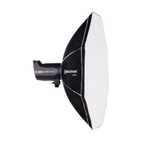 Elinchrom_Rotalux_Octabox_100cm_001 Mustavalkoinen Elinchrom Rotalux Octabox 100cm -studiostrobovalaisin ja siihen liitetty kahdeksankulmainen softbox, sivulta katsottuna valkoista taustaa vasten.