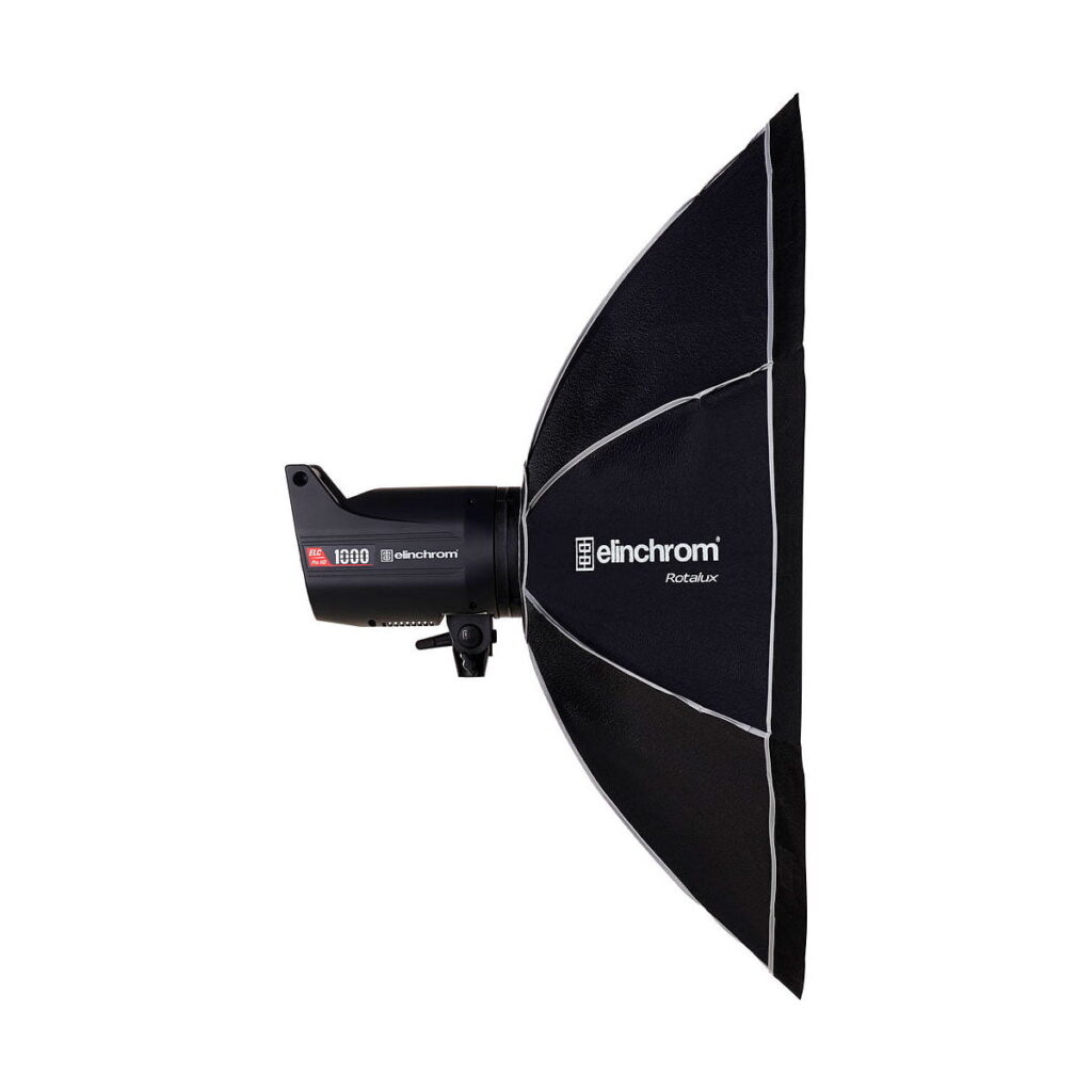 Elinchrom_Rotalux_Octabox_100cm_002 Ammattimainen studiostroboskooppivalaisin, jossa on suuri, musta Elinchrom Rotalux Octabox 100cm softbox, näkyy valkoisella taustalla.