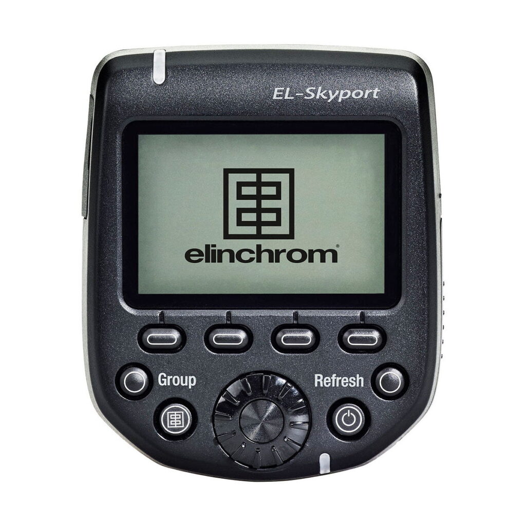 Elinchrom_Transmitter_Pro_001 Musta Elinchrom Transmitter Pro - Canon, jossa on Elinchromin logon näyttävä näyttö ja viisi merkittyä ohjauspainiketta ryhmää ja päivitystä varten.
