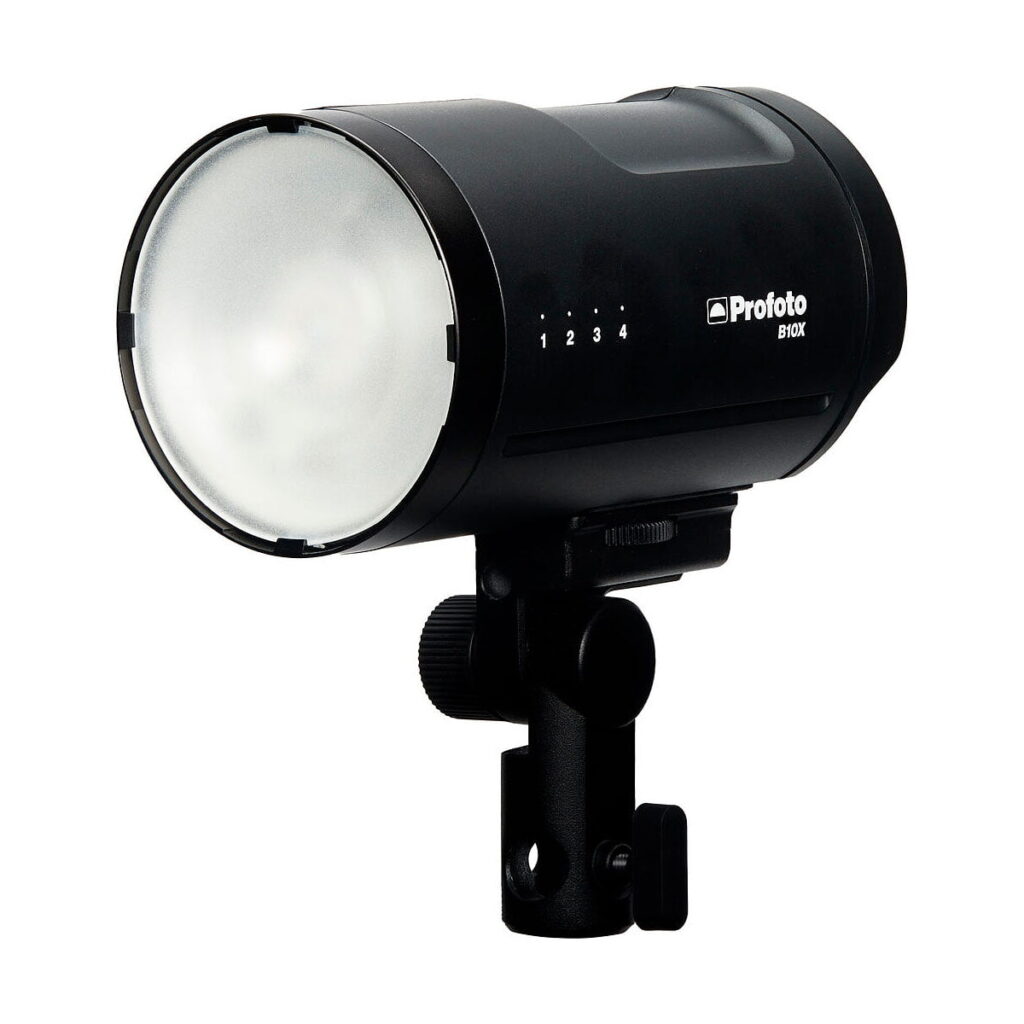 Profoto_B10X_OCF_012 Musta Profoto B10X OCF -studiovalaisin, jossa on pyöristetty etuhajotin, säätönuppi ja kiinnitysteline, on kuvattu valkoista taustaa vasten.