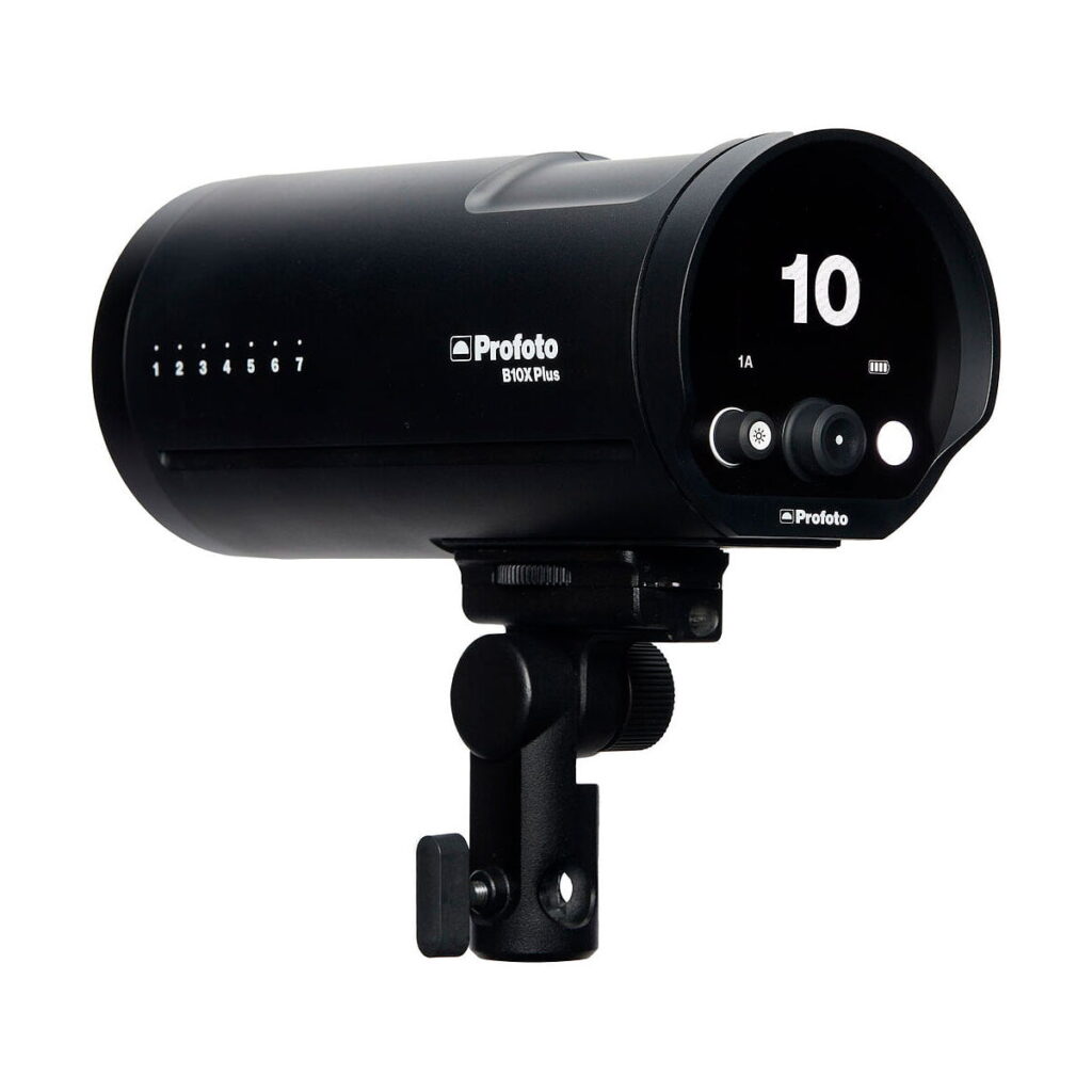 Profoto_B10X_OCF_Plus_010 Musta Profoto B10X Plus OCF -studiovalaisin, jossa on digitaalinen näyttö, jossa näkyy 10 ja ohjauspainikkeet, asennettuna säädettävään kiinnikkeeseen valkoista taustaa vasten.