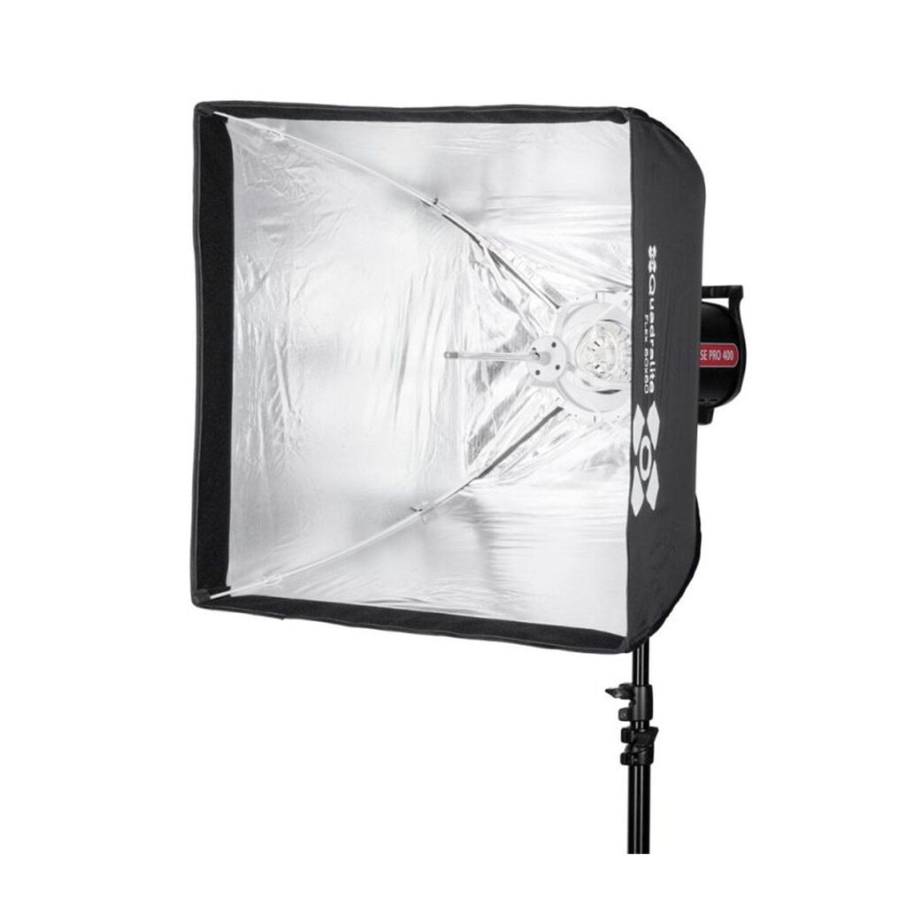 Quadralite_Flex_60x60_Fast_Folding_Softbox_002 Quadralite Flex 60x60cm Fast Folding Softbox, jossa on heijastava hopeinen sisäpuoli, on asennettu mustaan jalustaan ja suunniteltu ammattimaiseen valokuvaukseen tai videovalaistukseen.