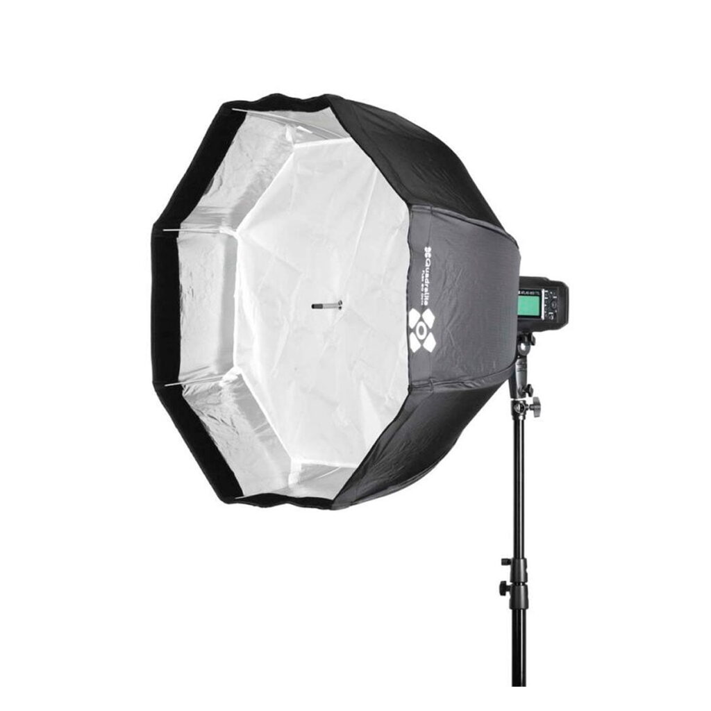 Quadralite_Flex_80_Octa_Fast_Folding_Softbox_002 Quadralite Flex 80cm Octa Fast Folding Softbox, kuvassa mustan ja hopean värinen, jalustalle asennettu salama, on suunniteltu ammattimaiseen valokuvaukseen ja eristetty valkoiselle taustalle.