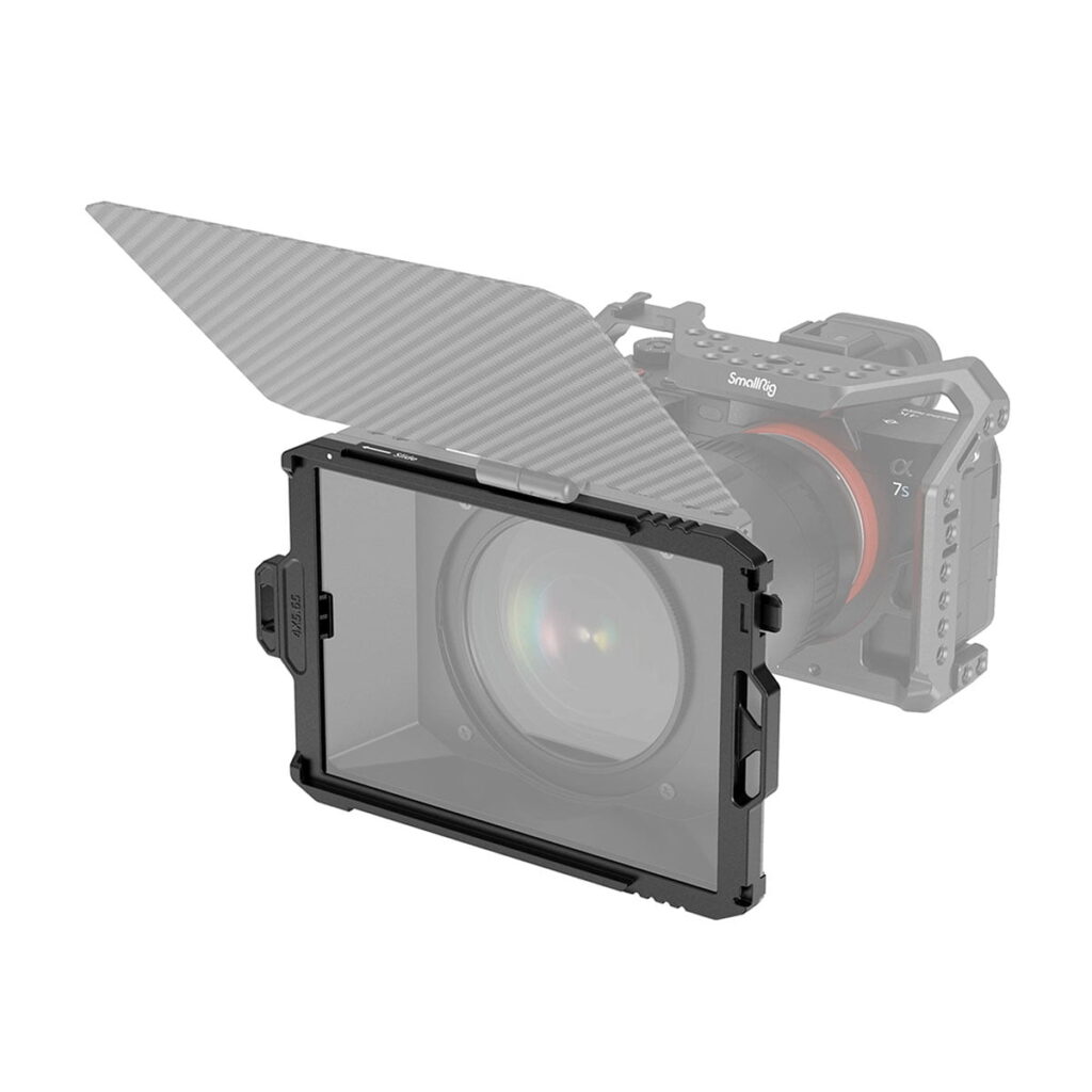 SmallRig_3319_Filter_Tray_4x5_65_001 SmallRig 3319 -suodatintelineellä (4 x 5,65) ja osittain avatulla, kulmikkaalla hiilikuituisella yläkannella varustettu kamera näkyy suojahäkissä, joka on sumeana taustalla.