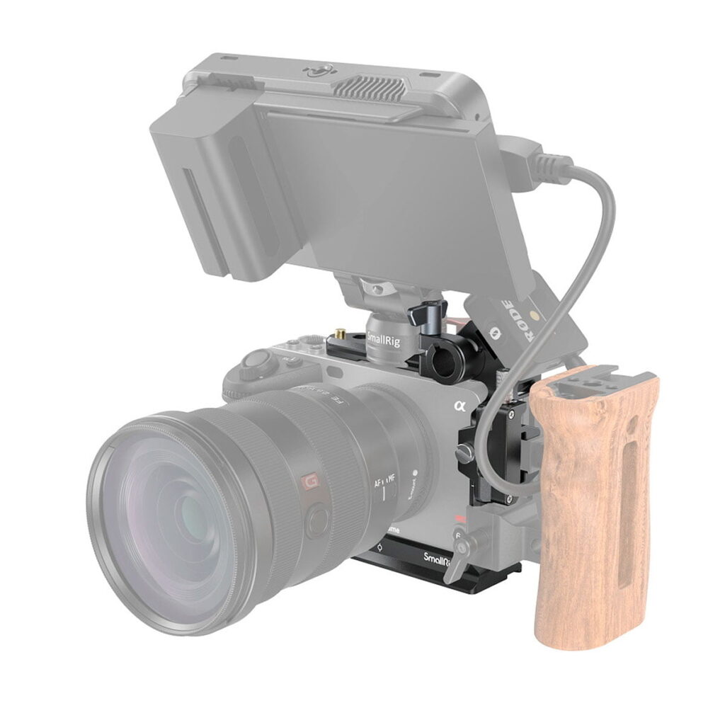 SmallRig Half Cage for Sony FX3 3278 -malliin mahtuu digitaalikamera, jossa on suuri objektiivi, ja siinä on puinen sivukahva sekä kameran yläpuolelle asennettu ja kaapelilla liitetty ulkoinen näyttö.