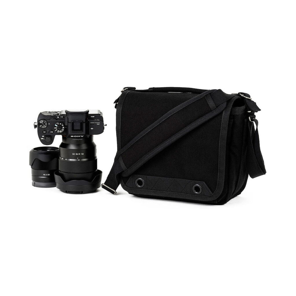 Think_Tank_Retrospective_4_V2_0-Musta_004 Think Tank Retrospective 4 V2.0 - The black camera bag appears black on a white background, and comes with a black camera with a detachable lens and an extra lens.