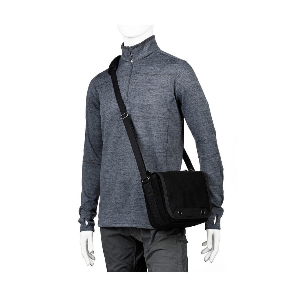 Think_Tank_Retrospective_4_V2_0-Musta_005 Dressed in a grey long-sleeved quarter-zip shirt and dark grey trousers, the mannequin carries a Think Tank Retrospective 4 V2.0 - Black crossbody messenger bag on his shoulder.