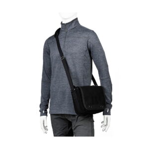 Think_Tank_Retrospective_4_V2_0-Musta_005 Dressed in a grey long-sleeved quarter-zip shirt and dark grey trousers, the mannequin carries a Think Tank Retrospective 4 V2.0 - Black crossbody messenger bag on his shoulder.