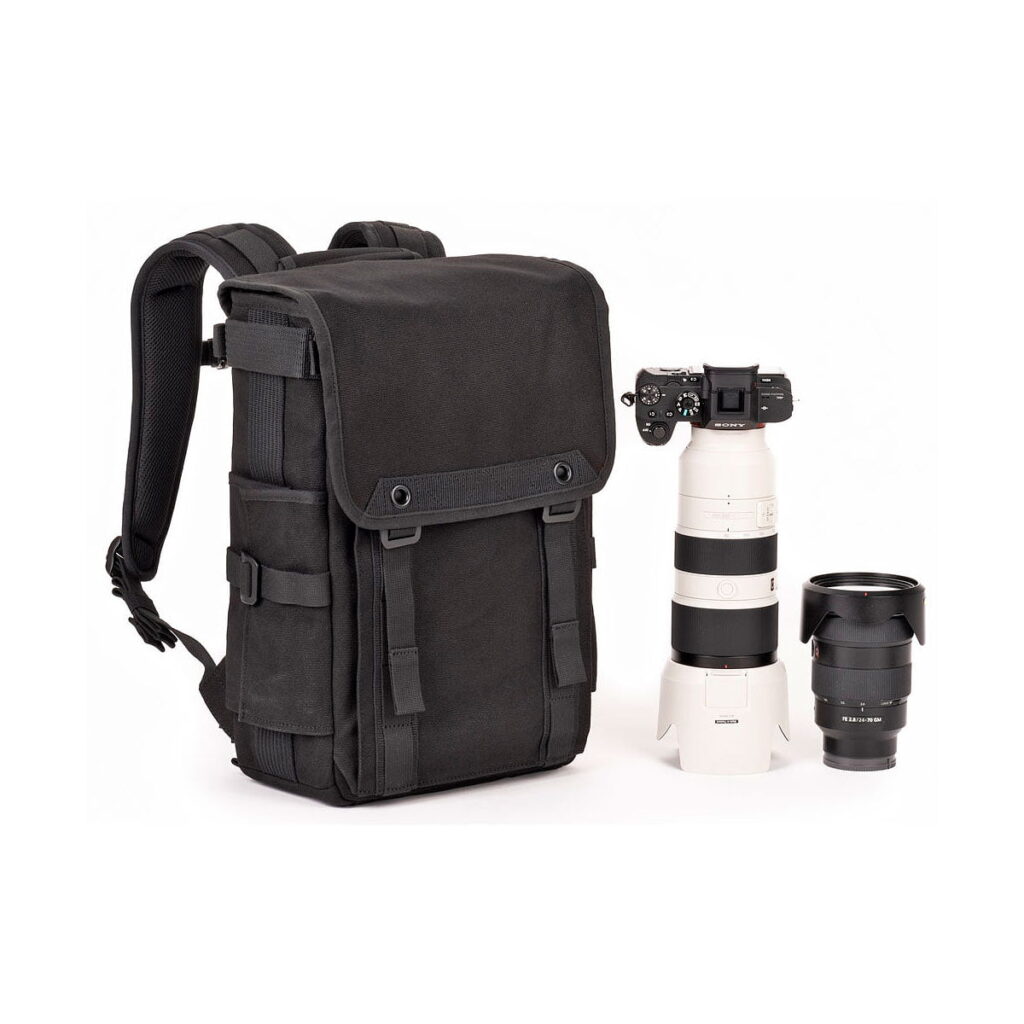 Think_Tank_Retrospective_Backpack_15-Black_008 The Think Tank Retrospective Backpack 15, black is shown on a white background next to a digital camera with a telephoto lens and an extra vertical lens.