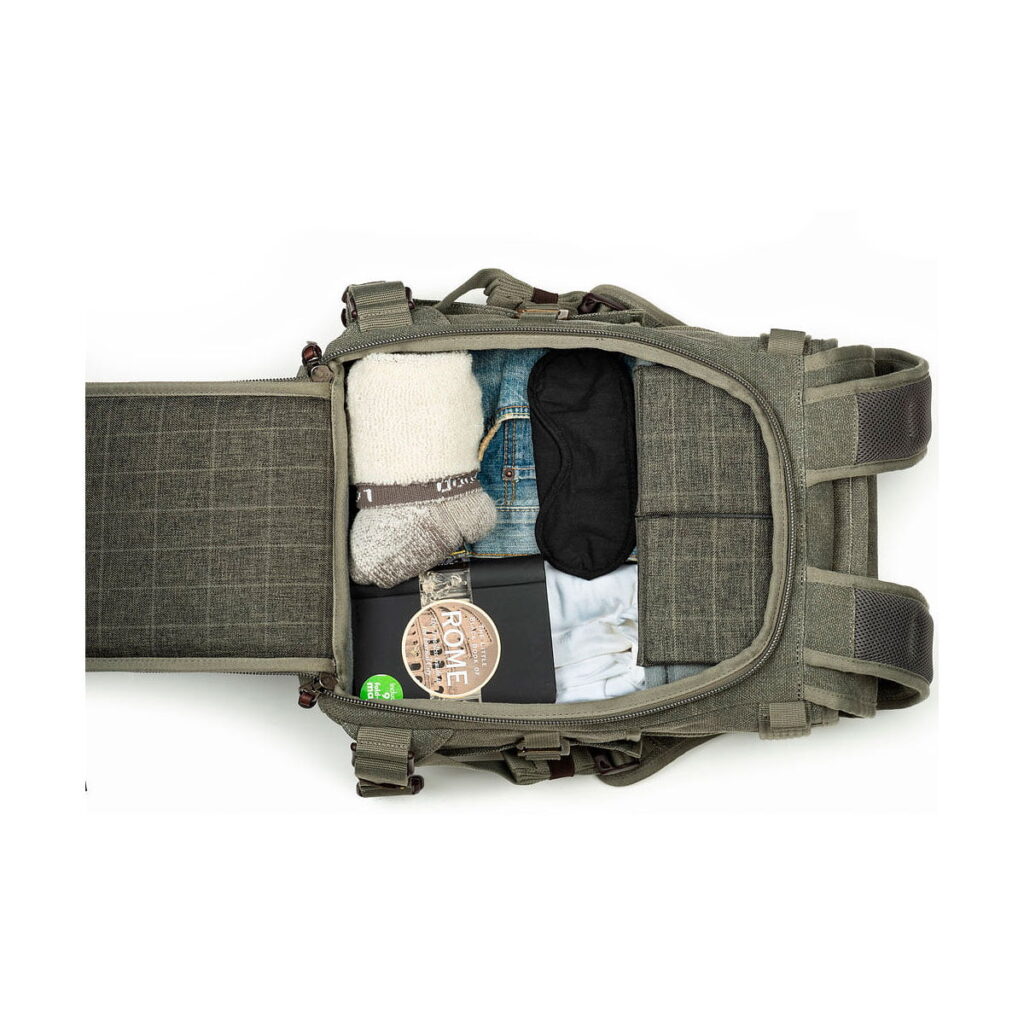 Think Tank Retrospective Backpack 15 -kamerareppu, pinestone, ylhäältä alaspäin avattuna niin, että päälokeroon on järjestetty siististi rullavaatteet, silmämaski, sukat, muistikirja ja pyöreä purkki.