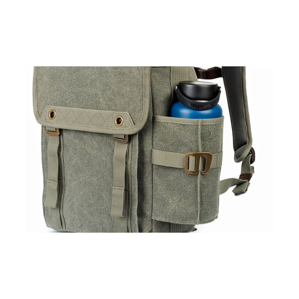 Pinestone Think Tank Retrospective Backpack 15 -reppu, jossa on etuläppä, kaksi hihnataskua ja sivutasku, jossa on sininen vesipullo mustalla kannella.