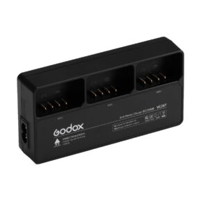 Musta Godox VC26T triplalaturi AD100 / Godox V1 -latauslaite, jossa on kolme latauspaikkaa, merkityt indikaattorit ja vasemmanpuoleinen pistorasia, joka on suunniteltu kameran akuille.