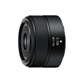 Nikon Nikkor Z 40mm f/2 -objektiivi näkyy mustana valkoista taustaa vasten, hieman vasemmalle suunnattuna. Objektiivissa on kuvioidut renkaat tarkkaa tarkennusta ja ohjausta varten.