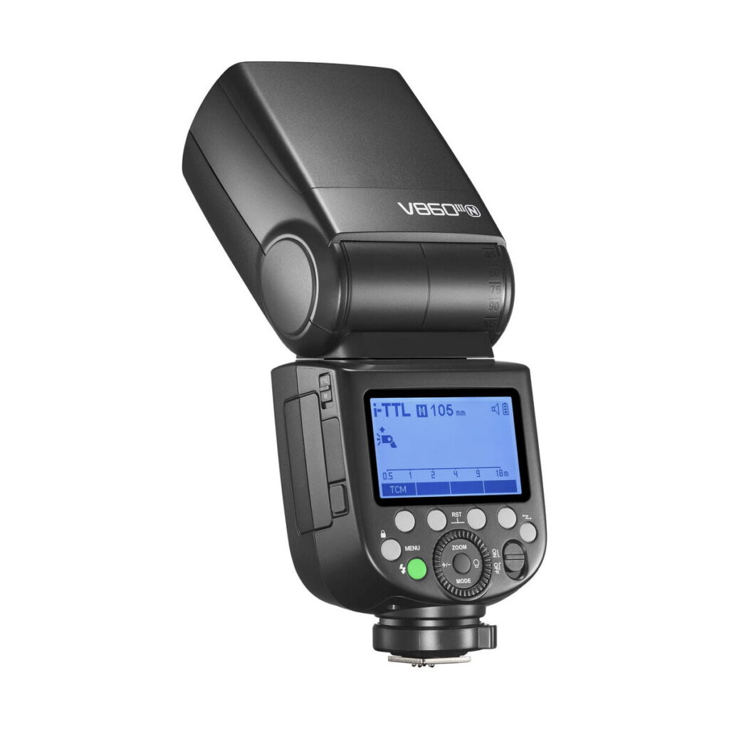 Godox-Ving-V860-III-TTL---Nikon-4 Musta Godox Ving V860 III TTL -ulkoinen salama Nikon-kameroille, jossa on digitaalinen näyttö, useita painikkeita ja ylöspäin kääntyvä pää; mallin nimi näkyy sivussa.