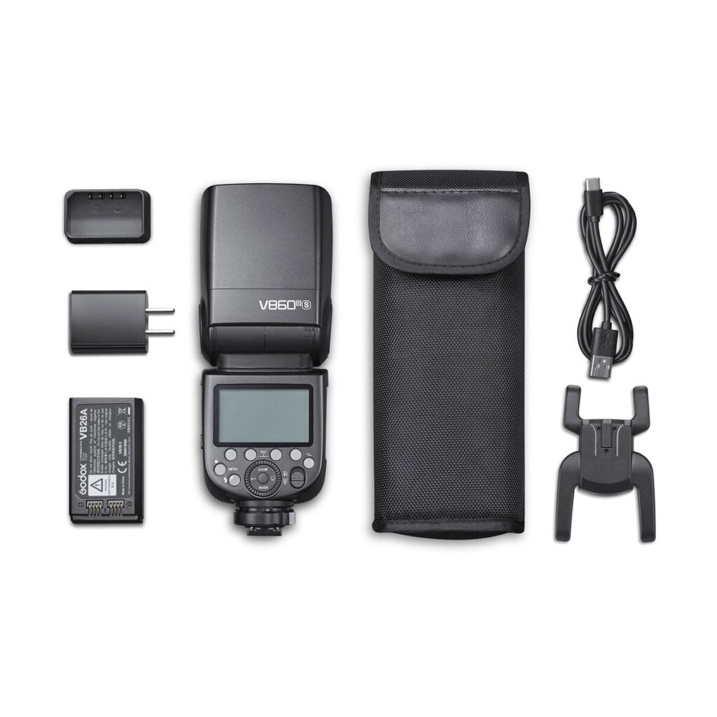 Godox-Ving-V860-III-TTL---Sony-1 A Godox Ving V860 III TTL flash for Sony cameras, battery, charger, wall adapter, carrying case, USB cable and tripod neatly arranged on a white background.