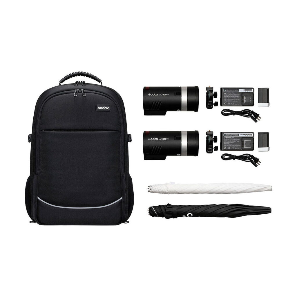 Godox_AD300_Outdoor_2-FLASH_Kit Godox AD300 Pro Outdoor 2-Flash Kit sisältää mustan repun, kaksi AD300 Pro -salamalaitetta, laturit akkuineen ja virtajohtoineen sekä yhden valkoisen ja yhden mustan taitetun sateenvarjon valkoisella pohjalla.