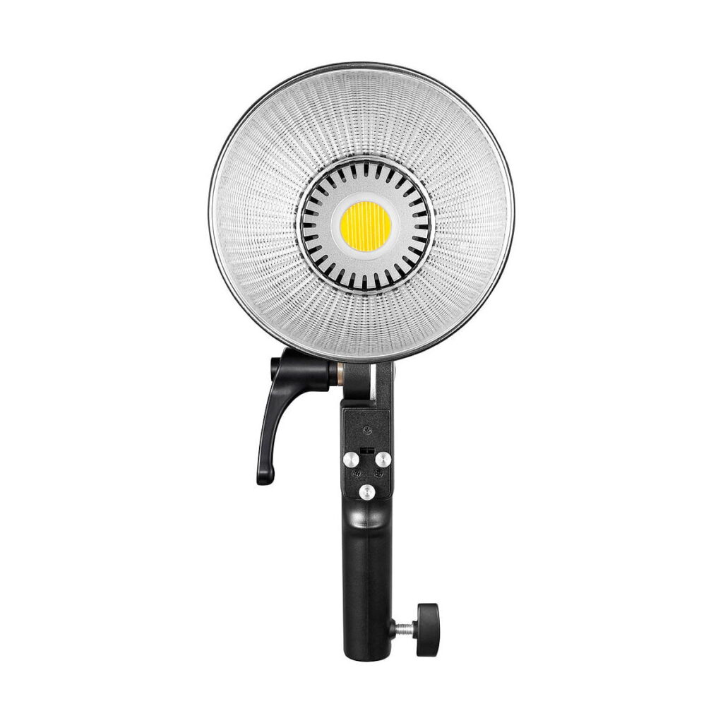 Godox_ML60Bi_Led_videovalo_004 Godox ML60Bi Led videovalo -LED-valossa on suuri pyöreä heijastin, musta kahva, jossa on ohjauspainikkeet ja säätönuppi, sekä keskeinen keltainen LED-valonlähde studiovideovalaistukseen.
