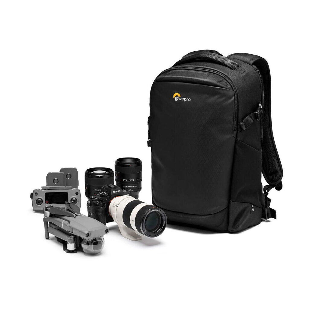 Lowepro_Flipside_300_AW_III-Musta_007 Lowepro Flipside 300 AW III -kamerareppu, musta, näkyy valkoisella pohjalla kameran objektiivin, kahden ylimääräisen objektiivin ja harmaan kauko-ohjaimella varustetun lennokin vieressä.