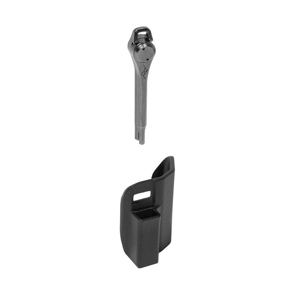Peak_Design_Travel_Tripod_Tool_Kit_002 Peak Design Travel Tripod -työkalusarjassa on musta metalliavain ja siihen sopiva musta muovinen holteri, jotka on kuvattu erikseen valkoisella pohjalla.