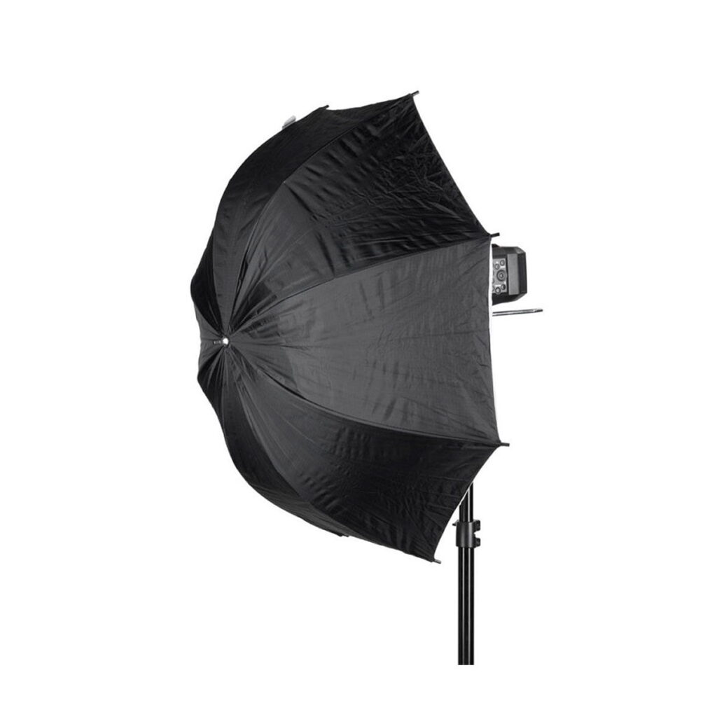 Quadralite_84_White_Umbrella_Softbox_003 Quadralite Umbrella Softbox 84cm on kiinnitetty valotelineeseen, ja studiosalamalaite on osittain näkyvissä sen takana valkoista taustaa vasten.