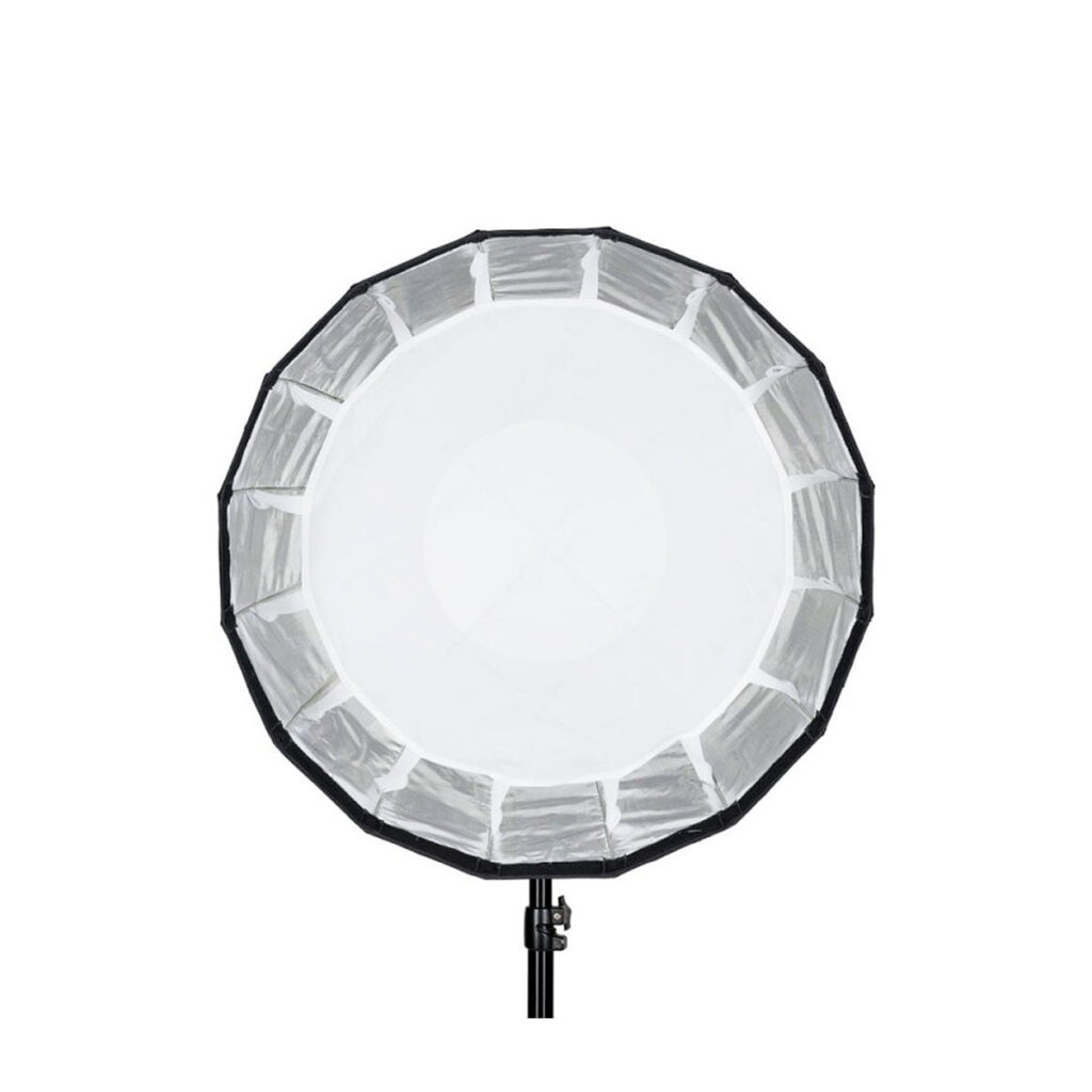 Quadralite_Flex_65cm_Foldable_Beauty-Dish_004 Quadralite Flex 65cm Foldable Beauty-Dish -valaisimessa on pyöreä softbox-malli, jossa on valkoinen diffuusori ja musta ulkoreuna. Se on asennettu mustaan jalustaan, ja se näkyy valkoista taustaa vasten.