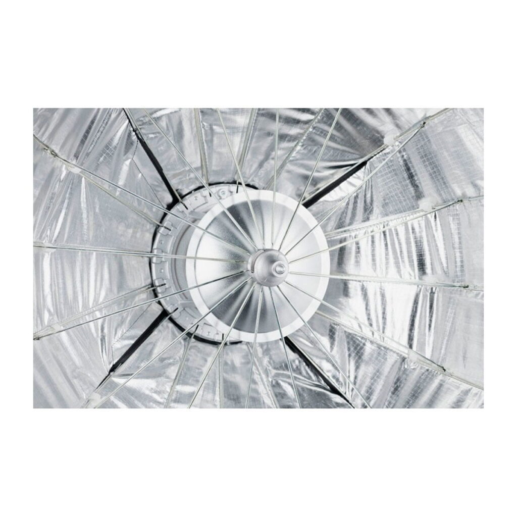 Quadralite_Flex_65cm_Foldable_Beauty-Dish_006 Lähikuvassa Quadralite Flex 65cm Foldable Beauty-Dishin sisustus, jossa korostuvat hopeanvärinen heijastava materiaali ja keskimmäisestä valopistokkeesta ulospäin ulottuvat metallipyöriä.