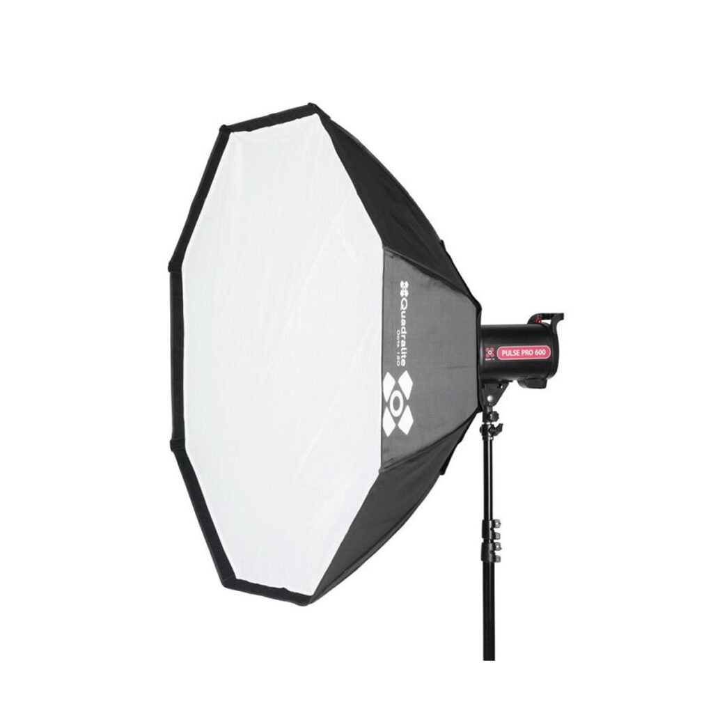 Quadralite_Softbox_120cm_001 Quadralite Softbox Octa 120cm on suuri kahdeksankulmainen softbox-valaisin, joka on asennettu mustaan studiotelineeseen, jossa on valkoinen diffuusoripaneeli ja näkyvät tuotemerkin logot sivulla.