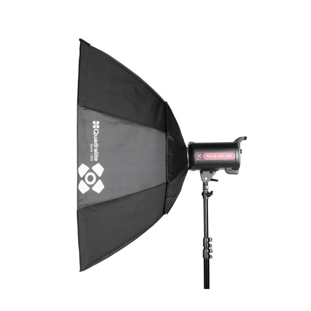 Quadralite_Softbox_120cm_002 Ammattimainen studiostroboskooppivalo, Quadralite Softbox Octa 120cm ja jalusta, kuvattu valkoista taustaa vasten. Laitteessa on merkintä Quadralite Pulse Pro 600.