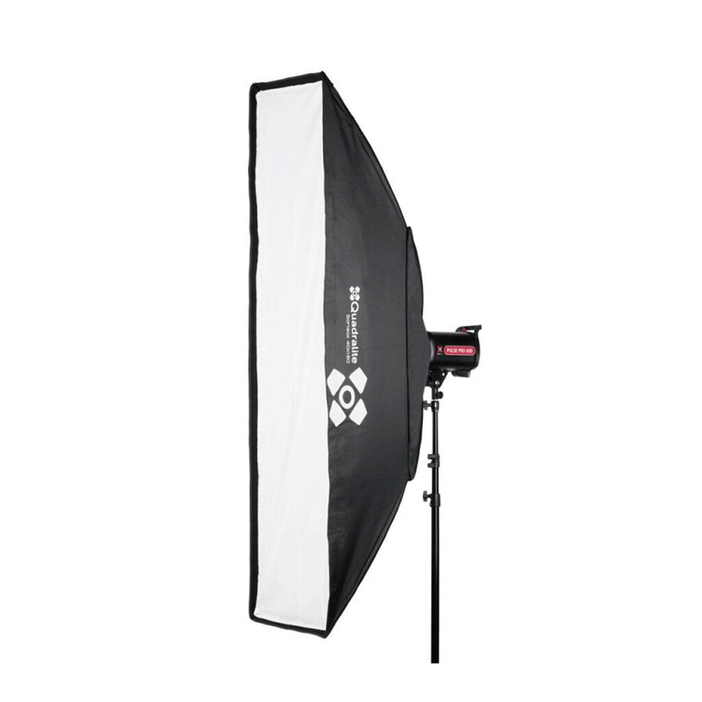 Quadralite_Softbox_40x180cm_001 Mustavalkoinen Quadralite Softbox 40x180cm näkyy sivulta kiinnitettynä studiovalotelineeseen valkoista taustaa vasten.