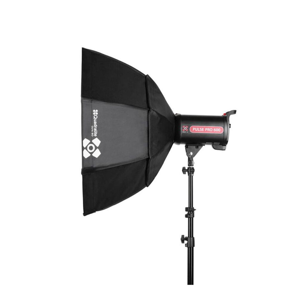 Quadralite_Softbox_80cm_002 Quadralite Softbox Octa 80cm, musta studiostroboskooppivalaisin, johon on kiinnitetty kahdeksankulmainen diffuusori, on asennettu jalustalle ja näytetään valkoista taustaa vasten. Softboxin kyljessä on valkoinen Quadralite-logo.