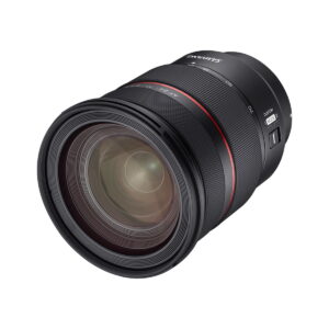 Samyang_AF_24-70mm_F_2_8_Sony_FE_005 Lähikuvassa Samyang AF 24-70mm F/2.8 Sony FE -objektiivin mustasta rungosta, etuelementin lähellä olevasta punaisesta renkaasta, sivukytkimistä ja merkinnöistä, kaikki valkoista taustaa vasten.