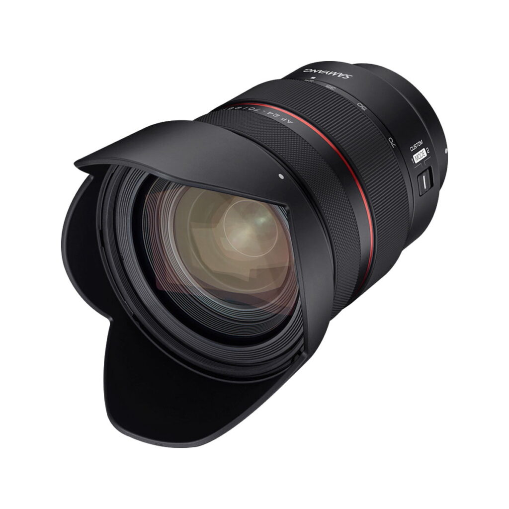 Samyang_AF_24-70mm_F_2_8_Sony_FE_006 Samyang AF 24-70mm F/2.8 Sony FE -objektiivi, jossa on terälehden muotoinen huppu ja yksityiskohtaiset tarkennusmerkinnät sen mustassa tynnyrissä, on kuvattu valkoista taustaa vasten näkyvillä lasielementeillä.