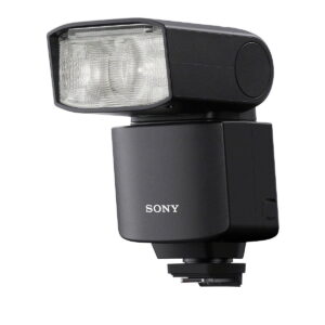 Sony_HVL-F46RM_003 Musta Sony HVL-F46RM -kameran ulkoinen salama, jossa on suorakulmainen, hieman ylöspäin kallistettu pää, on asennettu kuuman kengän jalustalle valkoista taustaa vasten.